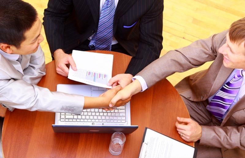 Businessmen shaking hands during a meeting.